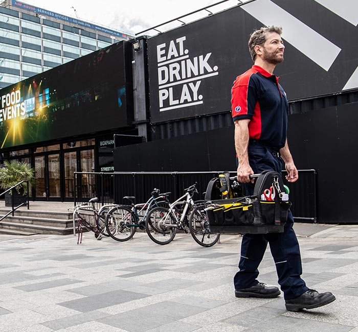 Pimlico engineer walking by billboards in Croydon