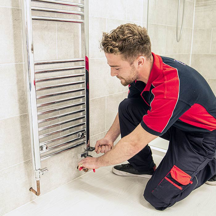 Heating engineer working on radiator