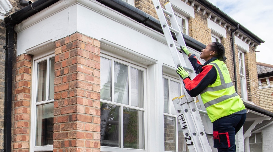 Pimlico Plumber climbing ladder outside house