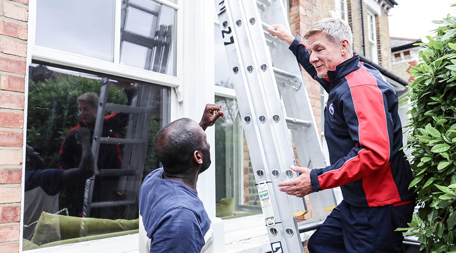 A pimlico climbs a ladder whilst answering a customer's question