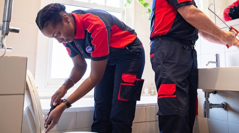 A Pimlico engineer fixes a toilet and runs sealant around the cistern