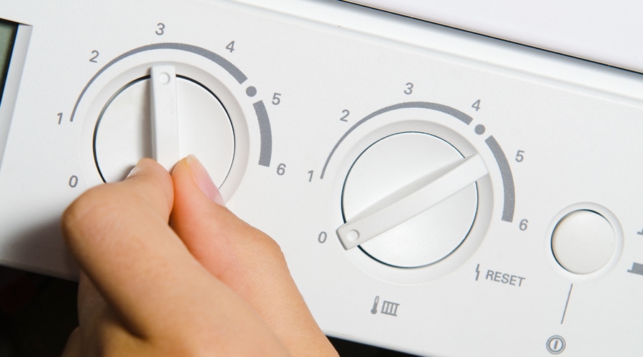 A homeowner tries to adjust the settings on their boiler