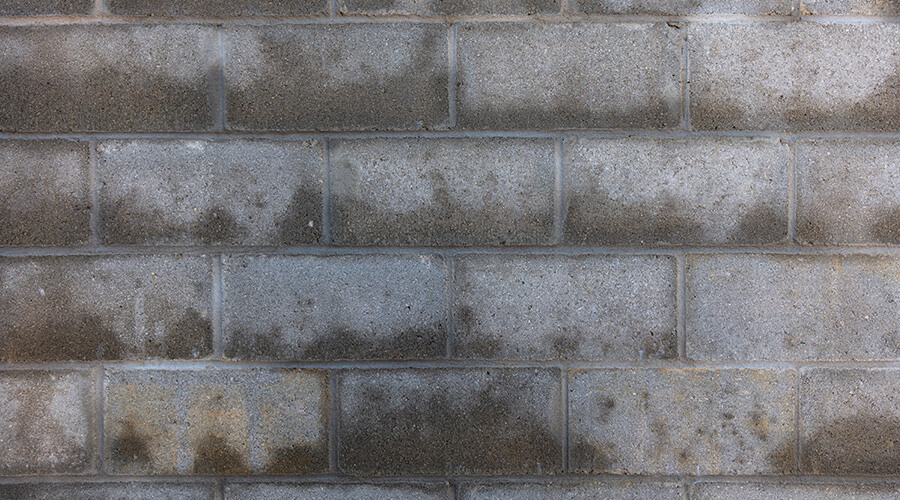 Breezeblock building, with wet patches absorbed into the brick