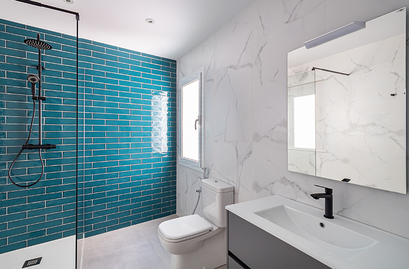essential bathroom with blue shower tiles