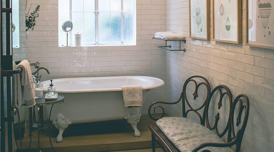 Vintage Victorian maximalist bathroom design with curve top claw bath 