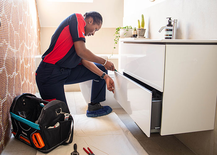 Tradesperson fixing a bathroom unit