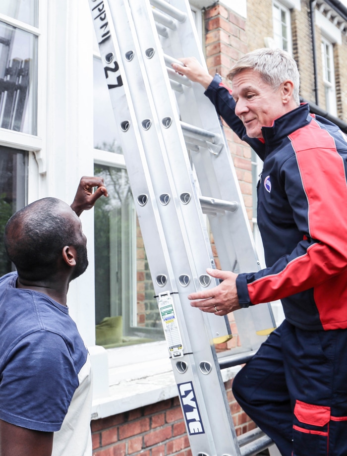 Pimlico roofing engineer on ladder talking with customer