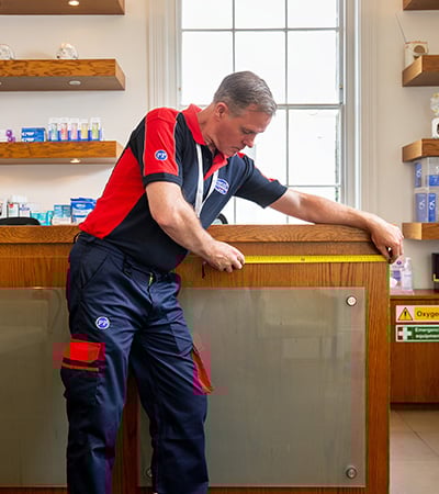 Pimlico carpenter measuring a reception desk