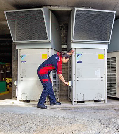 Pimlico air con technician checking an external air con unit