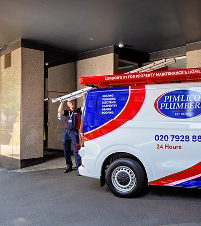 Pimlico roofer getting a ladder on his van