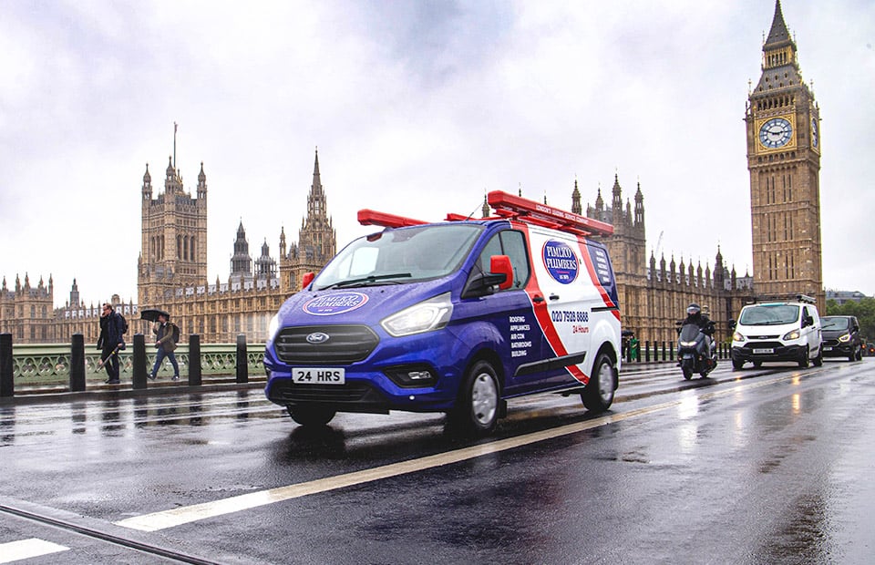 Pimlico plumbers van driving across westminster bridge