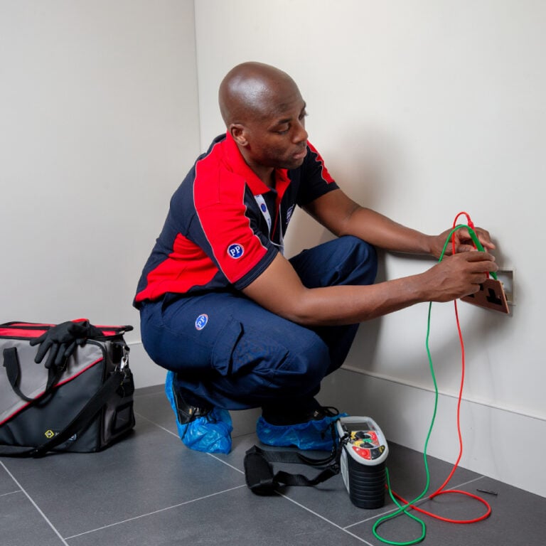 Electrician testing wiring in wall socket