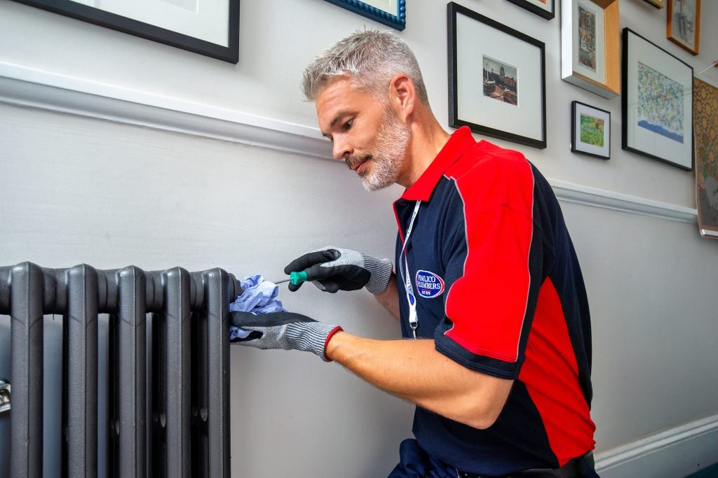 gas safe-registered heating engineer fixing a radiator