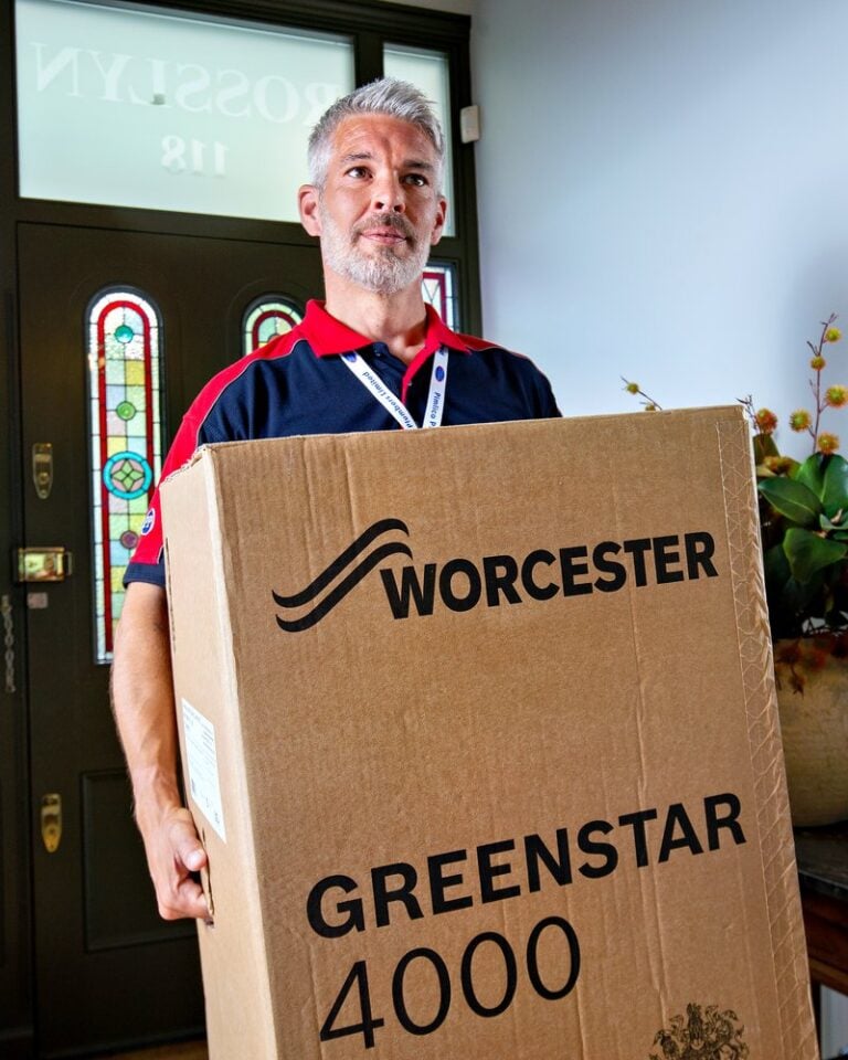 Gas safe engineer carrying a box containing a new boiler ready for installation