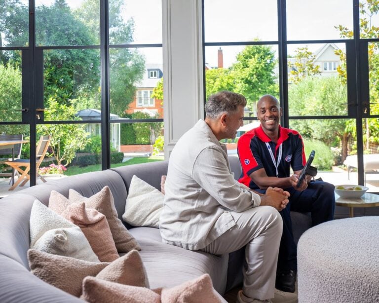 An engineer and homeowner smiling on a sofa