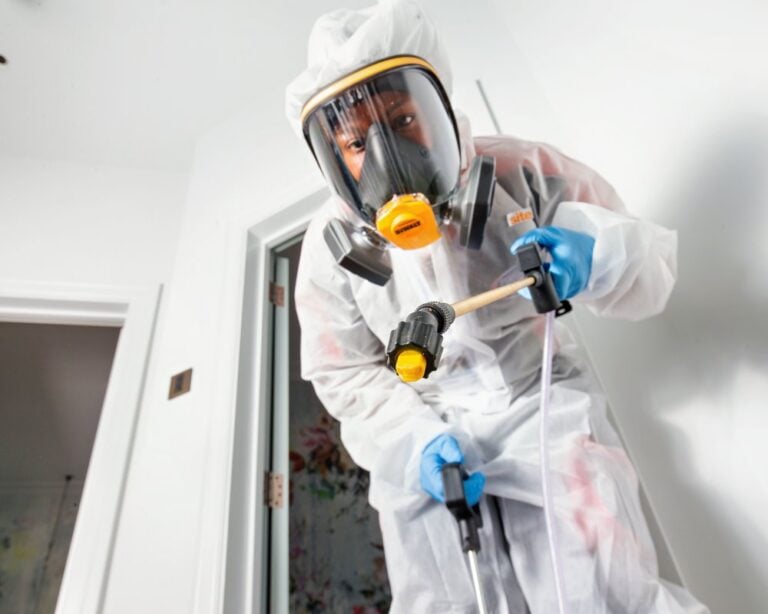 A pest control specialist in protective gear