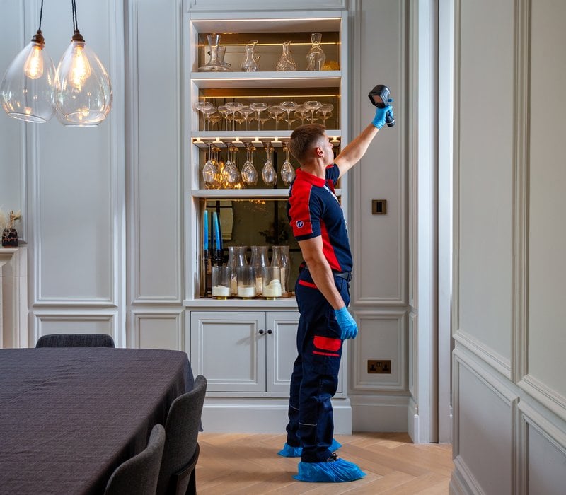 A damp and leak detection plumber scanning a wall
